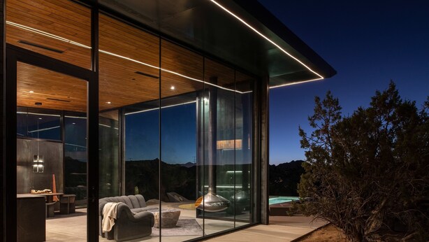 A modern house with a glass facade, a dining area, and a pool. - Obsidian - Industrial-Modern Villa (Yucca Valley)