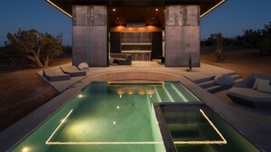 A modern outdoor pool area with a bar and seating, surrounded by a concrete structure. - Obsidian - Industrial-Modern Villa (Yucca Valley)