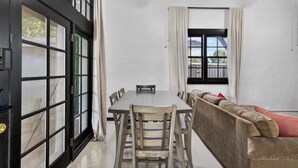 A dining area with a table, chairs, a sofa, and a ceiling fan. - Historic Firehouse within a short stroll to Downtown Chandler, 2 beds, 1 bath,   (Chandler)