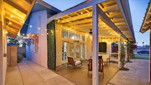 A covered outdoor seating area with string lights, a bench, and a door marked '290'. - Historic Firehouse within a short stroll to Downtown Chandler, 2 beds, 1 bath,   (Chandler)
