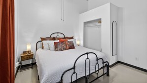 A bedroom with a bed, bedside table, lamp, and a wardrobe. - Historic Firehouse within a short stroll to Downtown Chandler, 2 beds, 1 bath,   (Chandler)