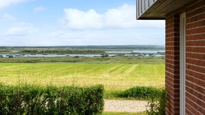 Uitzicht vanaf een bakstenen gebouw, met een grindpad dat naar een grasveld leidt.