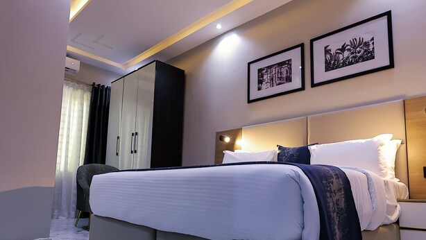 Une chambre à coucher moderne avec un grand lit, une armoire et une table de chevet.