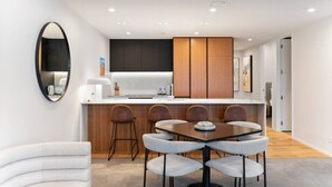 Une cuisine moderne dotée d’un îlot central, de tabourets de bar et d’une table à manger avec des chaises.