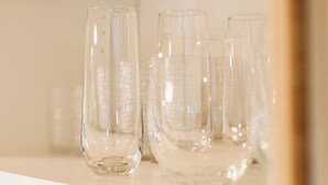 Três vasos de vidro transparente sobre uma prateleira branca.
