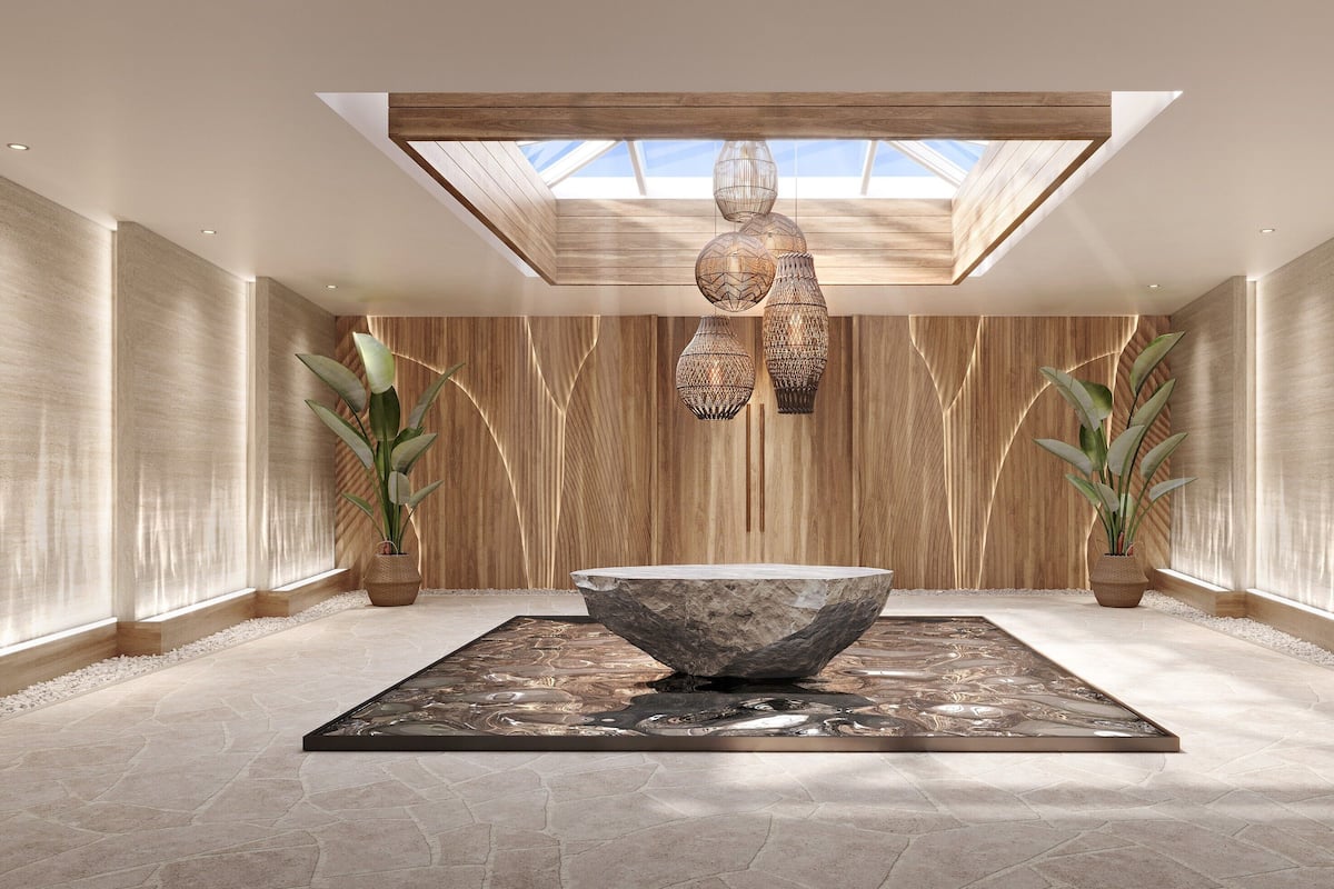 Un spa moderno con una amplia cuenca de piedra, paredes de paneles de madera y lámparas colgantes.