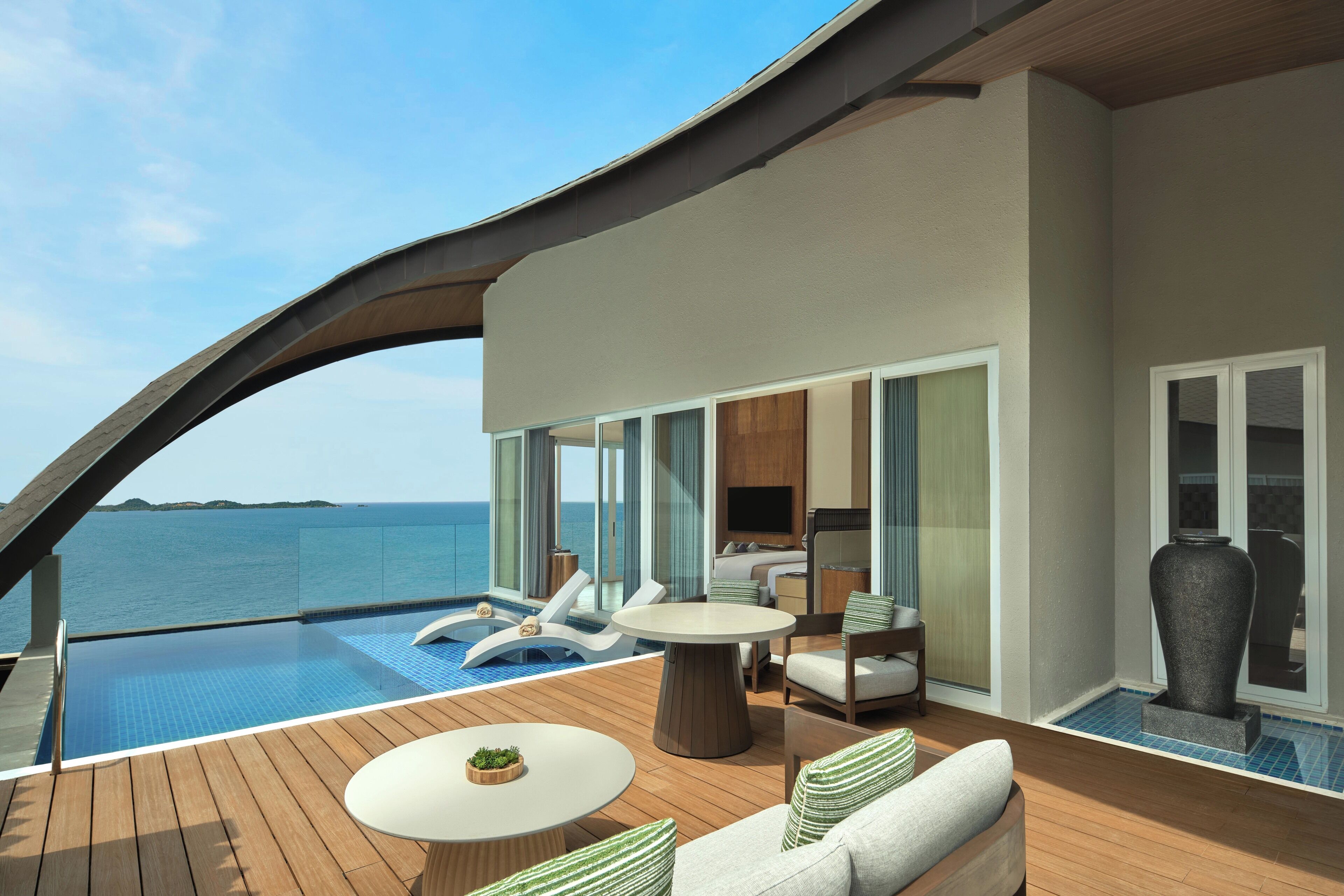 A modern deck with a pool, lounge chairs, a dining table, and a sofa.