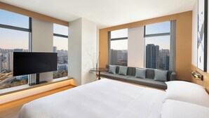 A modern hotel room with a large bed, a TV, a sofa, and a city view. - Fairfield by Marriott Hangzhou Gongshu (Hangzhou)