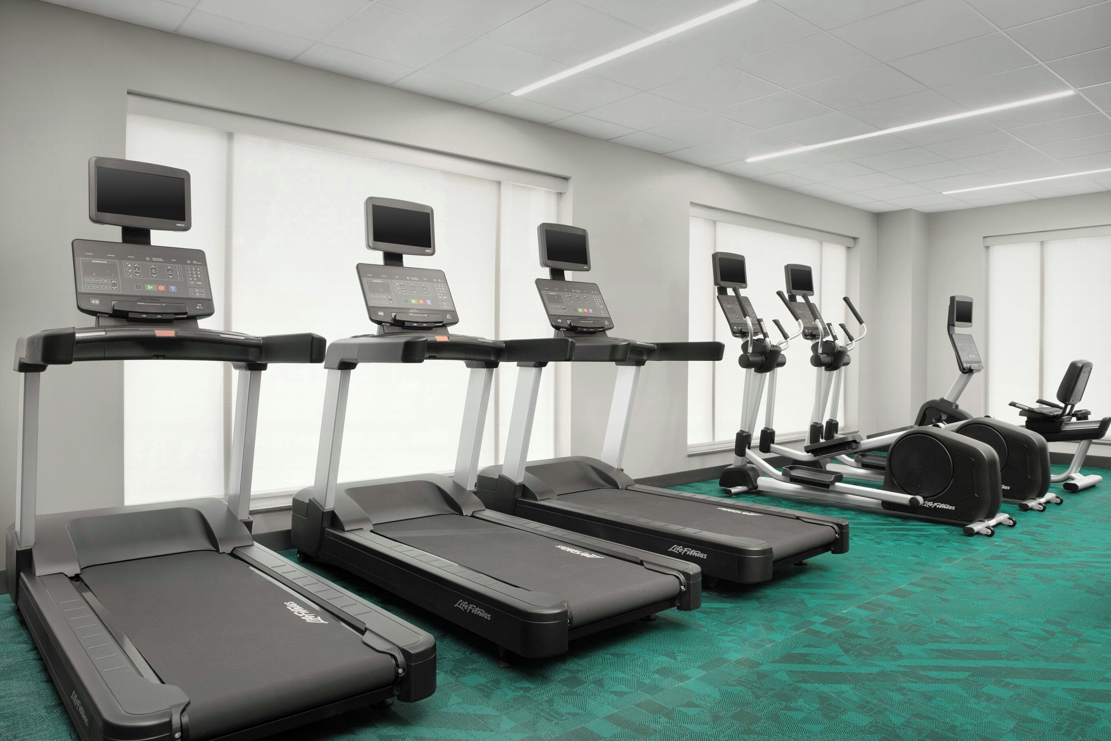 A fitness center with treadmills, elliptical machines, and a stationary bike.
