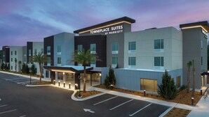 A modern hotel with a sign reading "Towneplace Suites by Marriott" and a parking lot in front. - TownePlace Suites by Marriott® Jacksonville Mayport (Atlantic Beach)