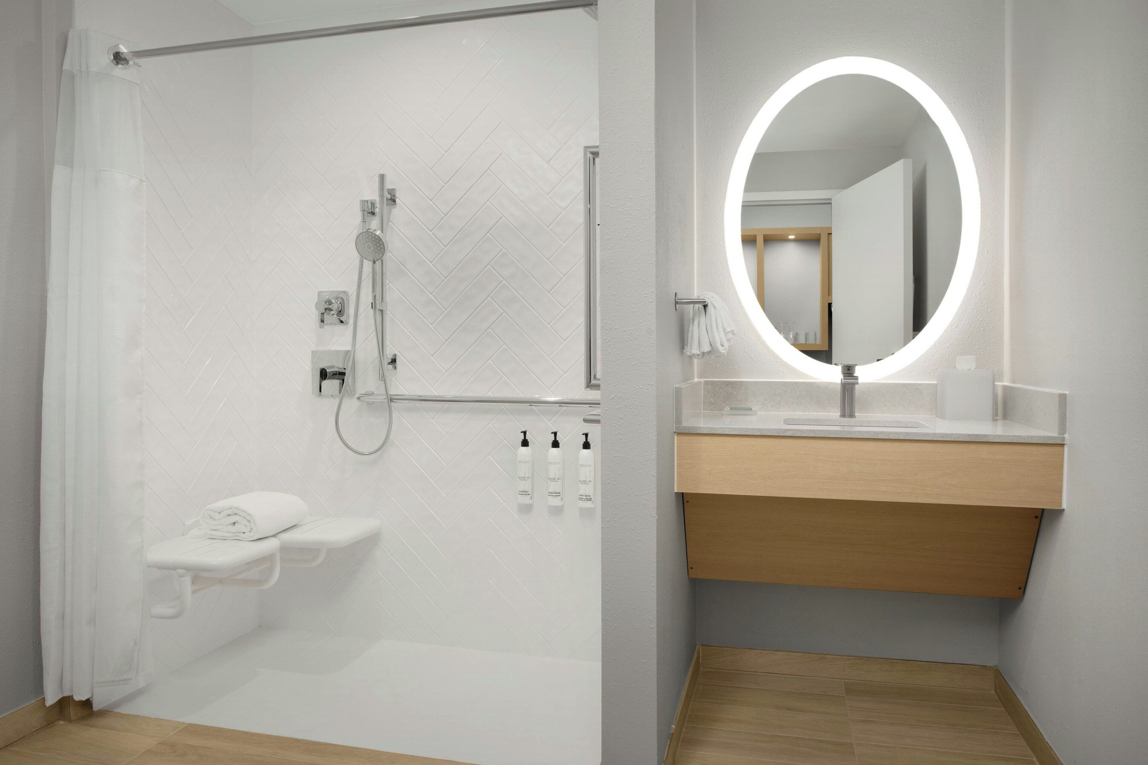 A modern bathroom with a shower, toilet, and vanity with a mirror.