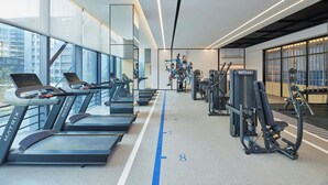 A modern gym with treadmills, weight machines, and a large mirror. - Four Points by Sheraton Shenzhen Guangming (Shenzhen)