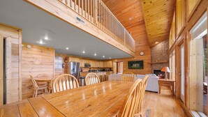 A wooden cabin with a dining area, kitchen, and living space. - Smoky Mountains Bliss - Cozy Cabin w/ Amazing Views, Perfect for Big Families!  (Sevierville)