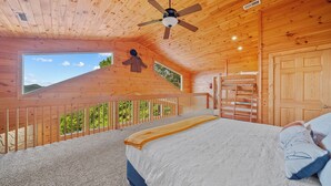 A bedroom with a bed, a ceiling fan, a window, and a door. - Smoky Mountains Bliss - Cozy Cabin w/ Amazing Views, Perfect for Big Families!  (Sevierville)