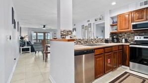 Eine moderne Küche mit Holzschränken, Edelstahlgeräten und einer gefliesten Spritzschutzwand.