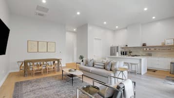 Cozy living space with a dining area, sofa, and kitchen, featuring a mix of modern and traditional elements.
