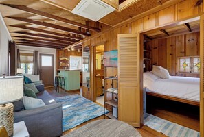 Una habitación acogedora con cama, sofá, pequeña cocina y baño.