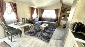 Un espacio habitable compacto con sofá, mesa de comedor y cafetera.