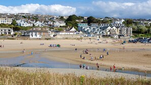 A beach with people, a water body, and houses in the background. - Cornwall Sea/Countryside Caravan with Hot Tub Family and Pet Friendly (Newquay)
