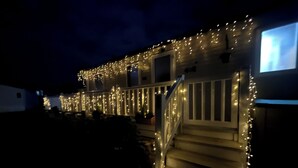 Una casa con un porche decorado con luces de cadena.