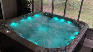 A hot tub with a view of the backyard through large windows. - Negreet Retreat#2 Clean Waterfront Midlake Toledo Bend Sleeps 12 with Hot Tub (Many)