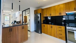 A modern kitchen with wooden cabinets, stainless steel appliances, and a central island. - Tranquil villa with AC and pool in Punta Cana (Punta Cana)