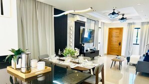 A modern dining area with a central island, a television, and a wooden door in the background. - Tranquil villa with AC and pool in Punta Cana (Punta Cana)