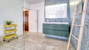 A bathroom with a large mirror, green cabinets, a wooden ladder, and a plant on a cart. - Casa Casa NoPasaNada, habitación Triple Los Lobos (Tinajo)