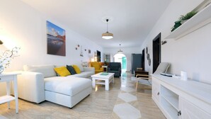 A modern living room with a sofa, coffee table, and a TV stand. - Casa Casa NoPasaNada, habitación Triple Los Lobos (Tinajo)
