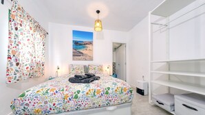 A bedroom with a bed, a wardrobe, and a painting on the wall.