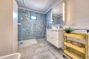 Regadera, secadora de cabello, toallas, papel de baño 