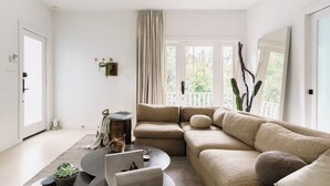Een moderne woonkamer met een ruime hoekbank, een bijzettafeltje en een potplant.
