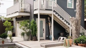 A two-story house with a balcony, a staircase leading to the second floor, and a swimming pool in the foreground. - High-style Home near Bishop Arts and Downtown Dallas (Dallas)
