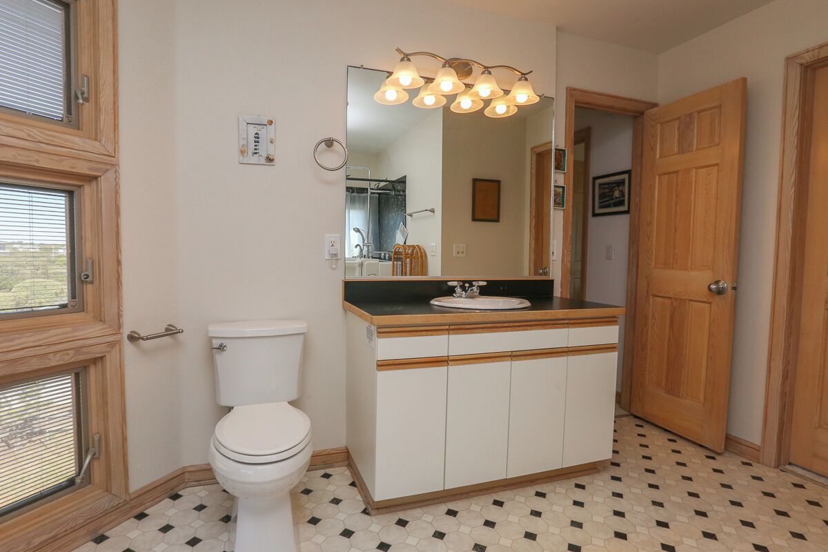 A bathroom with a toilet, a sink, and a mirror.