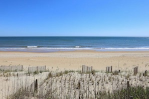 A beach with sand dunes and wooden fences.