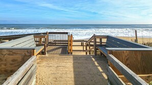 A wooden boardwalk leading to a beach with a wooden bench and a sign indicating a short distance to the beach. - Anchor Aweigh - 4 BR Home in Southern Shores w/Private Pool (Southern Shores)