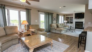 A spacious living room with a sofa, armchairs, a coffee table, and a fireplace. - Pelican's Way - 4 BR Oceanfront Cottage in Southern Shores (Southern Shores)