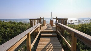 A wooden boardwalk leading to a beach with a clear view of the ocean. - Pelican's Way - 4 BR Oceanfront Cottage in Southern Shores (Southern Shores)