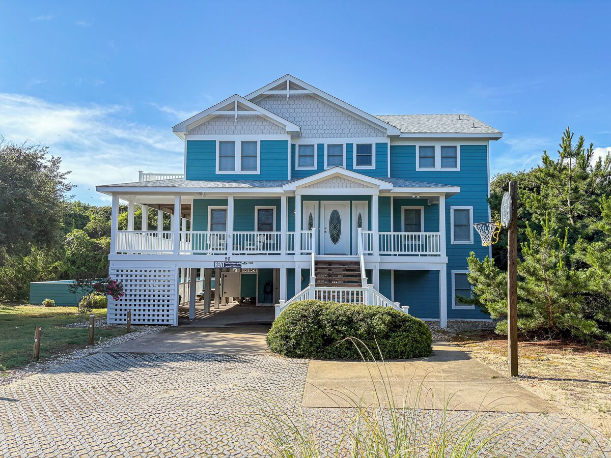 A two-story house with a porch, a front door, and a basketball hoop.