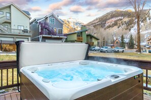 Una vasca idromassaggio su un patio con montagne sullo sfondo.