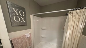 Un baño con bañera, inodoro y cortina de ducha.