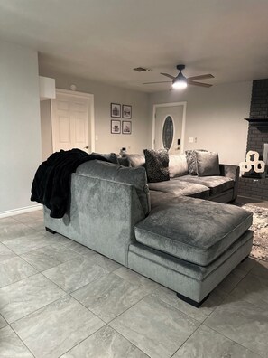 A living room with a grey sectional sofa, a ceiling fan, and a fireplace. - Horseshoe Bay & Marble Falls TX SLEEPS 16 Three KING Beds Boat Rental (Horseshoe Bay)