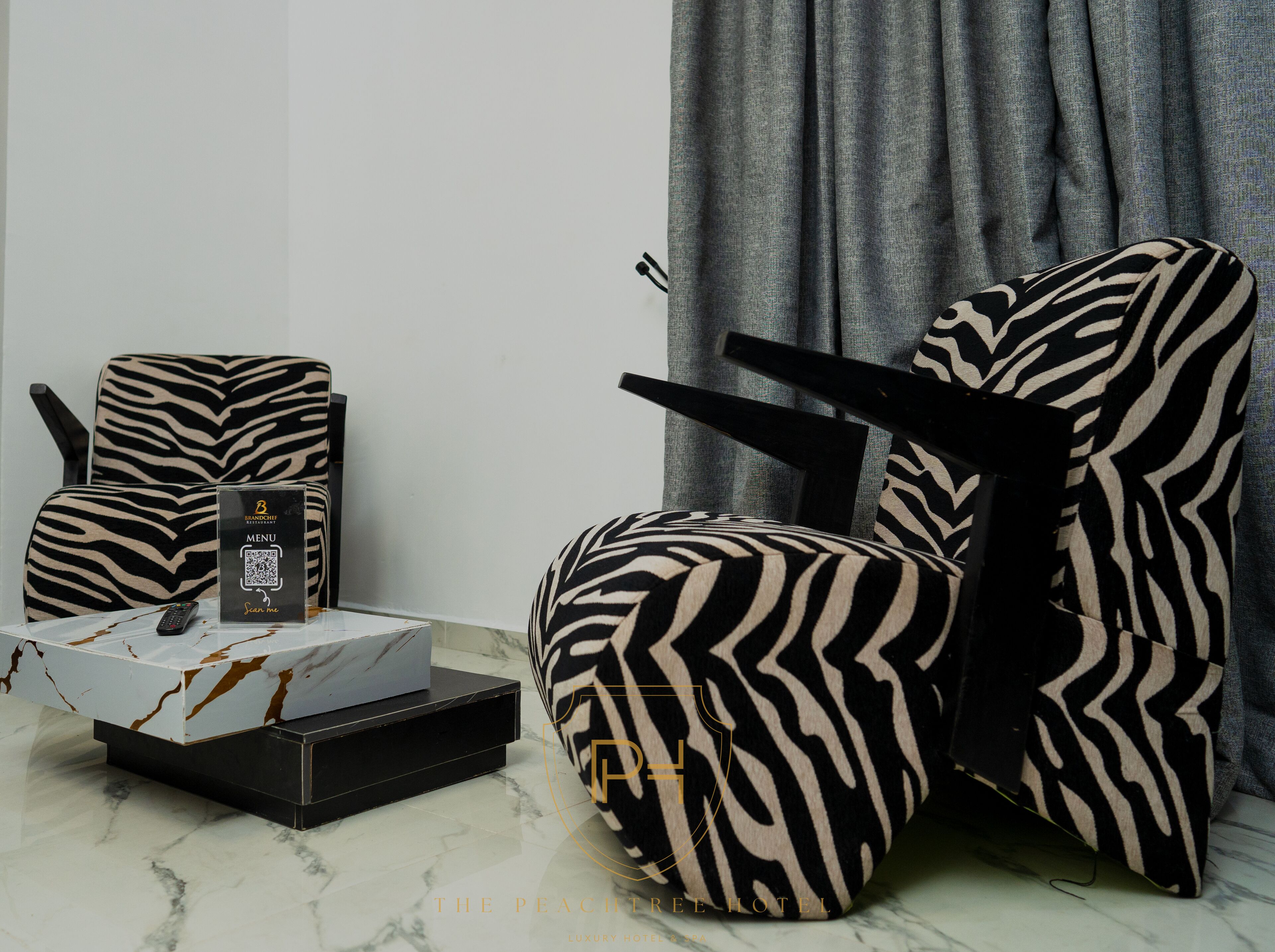Una habitación moderna con una silla estampada de cebra, un control remoto y un atril para menús.