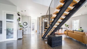 A spacious living area with a modern staircase, a sofa, and a coffee table.