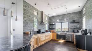 A modern kitchen with granite countertops, wooden cabinets, and a large island.