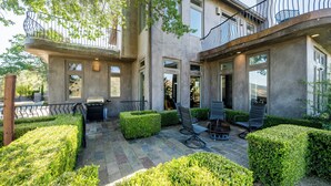 A modern house with a patio, outdoor seating, and a fireplace.