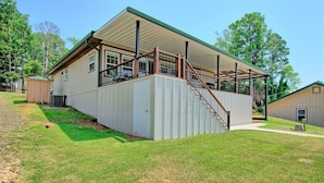 A single-story building with a covered porch and a staircase leading to a deck. - Lakefront Home -Private Dock, Fishing and Stunning Views (Milam)