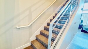 A staircase with carpeted steps and a metal railing.