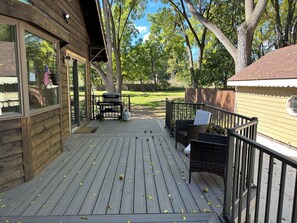 A wooden deck with outdoor furniture, a barbecue grill, and a view of the surrounding yard. - Charming 6-bedroom house in marvelous Rochester Hills with a fitness room, WiFi (Rochester Hills)