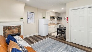 A compact living space with a kitchenette, a dining area, and a fireplace. - Stylish Studio Near German Village, Sleeps 4 , Café + Cowork (Columbus)